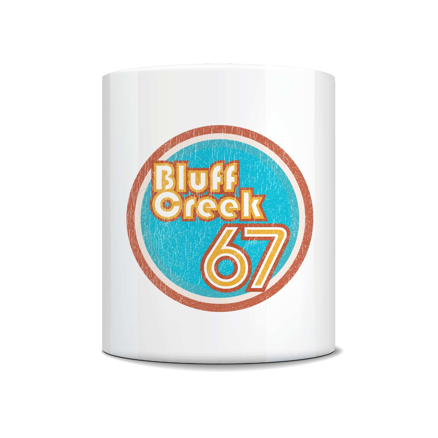 A white ceramic mug featuring a circular retro-style graphic with the text 'Bluff Creek 67' in orange and yellow on a textured light blue background, set against a plain white studio backdrop.